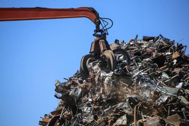 Close-up industrial claw machine, move scrap metal in the landfill. Excavator armسكراب بالرياض برق الرياض, claw crane.